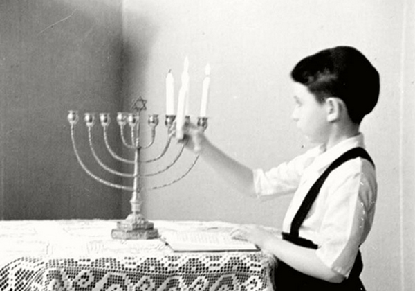 ילד מדליק חנוכיה בשנות ה-30' בברלין. מקור: אתר יד ושם
